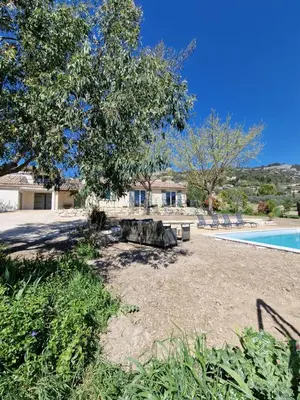 a yard with a picnic table and a swimming pool at L'Oustalet des Vignes in Saint-Saturnin-les-Apt