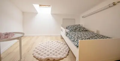 a bedroom with a bed and a table and a rug at Appartement T4 plein centre ville escalier étroit in Aix-en-Provence