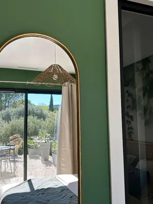 a mirror in a bedroom with a view of a patio at Le Bonheur à Ventoux in Saint-Pierre-de-Vassols