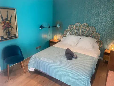 a bedroom with a bed with a blue wall at Atypical 5-person house with patio, downtown, air-conditioning in Aix-en-Provence