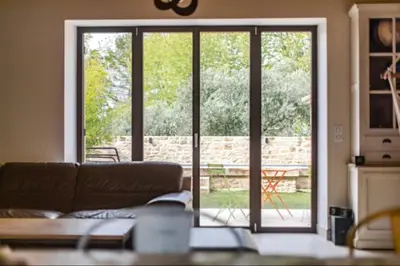 a living room with a couch and a sliding glass door at Coudignac 1891 in Lagnes