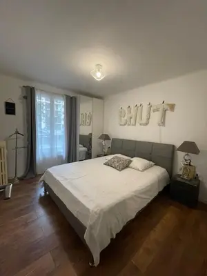 a bedroom with a large bed with white sheets at bel appartement T3 Aix Nord in Aix-en-Provence
