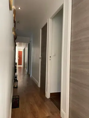 a hallway with white walls and a wooden floor at bel appartement T3 Aix Nord in Aix-en-Provence