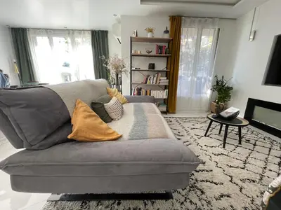 a living room with a gray couch and a table at bel appartement T3 Aix Nord in Aix-en-Provence