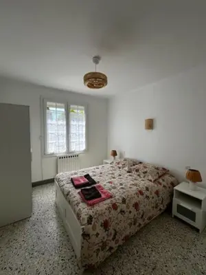 a bedroom with a bed with a red blanket at Charmant appartement rénové, à 15 mn d'Avignon et de son festival in Entraigues-sur-la-Sorgue