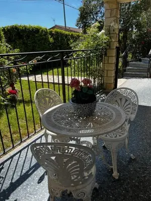 a table and chairs with a vase of flowers on it at Charmant appartement rénové, à 15 mn d'Avignon et de son festival in Entraigues-sur-la-Sorgue