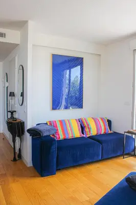 a blue couch with colorful pillows in a living room at Spacious Duplex with Terrace City Center in Aix-en-Provence