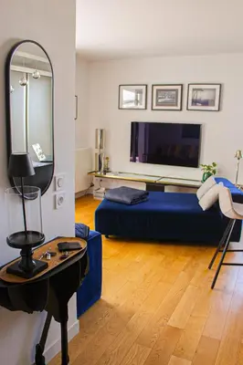 a living room with a bed and a mirror at Spacious Duplex with Terrace City Center in Aix-en-Provence