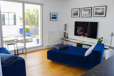 a living room with a blue couch and a tv at Spacious Duplex with Terrace City Center in Aix-en-Provence