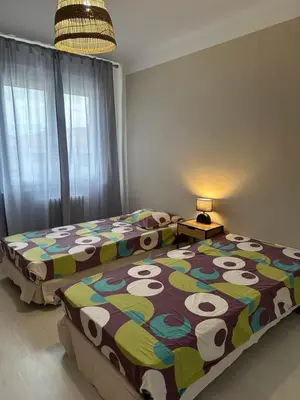 a bedroom with a white bed with pink flowers on it at Appartement Lumineux avec Balcon in Carpentras