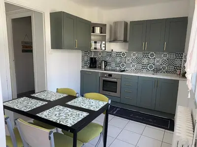a living room with a table and a couch at Appartement Lumineux avec Balcon in Carpentras