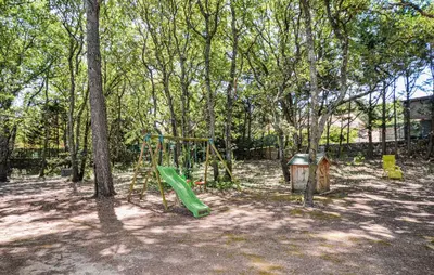 a playground with a green slide and trees at Lovely Home In St Cannat in Saint-Cannat