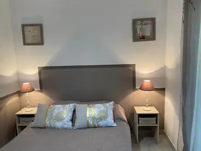 a bedroom with a bed with two lamps on tables at Le gîte de Cambuisson in Velleron