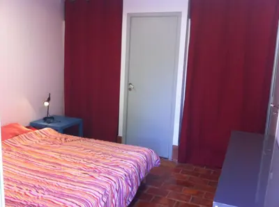 a bedroom with a bed and a red curtain at Maisonnette dans un parc du 18ème in Aix-en-Provence