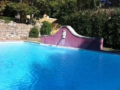 a swimming pool with a slide in the middle at Maisonnette dans un parc du 18ème in Aix-en-Provence