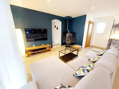 a living room with a white couch and a tv at En Provence, Luberon, villa avec piscine à Maubec in Maubec