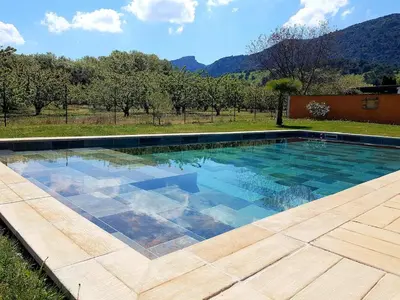 a swimming pool in a yard with a mountain in the background at En Provence, Luberon, villa avec piscine à Maubec in Maubec