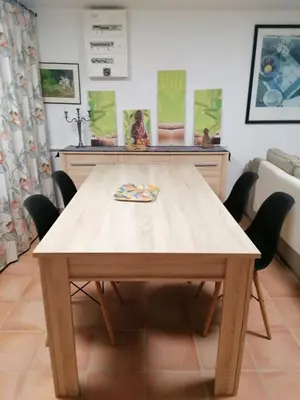 a wooden table in a living room with chairs at Les chênes du lac in Saint-Saturnin-les-Apt