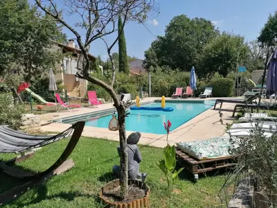 a swimming pool in a backyard with a tree in the yard at Les chênes du lac in Saint-Saturnin-les-Apt