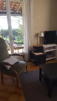 a living room with a couch and a chair and a tv at Maison de charme en Luberon à proximité de Lourmarin piscine privée et grand jardin in Puyvert