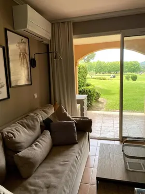 a living room with a couch and a sliding glass door at Élégant appartement sur le Golf de Pont Royal in Mallemort