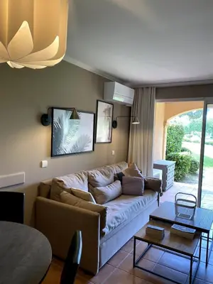 a living room with a couch and a table at Élégant appartement sur le Golf de Pont Royal in Mallemort