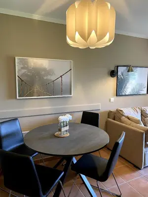 a dining room with a table and chairs and a couch at Élégant appartement sur le Golf de Pont Royal in Mallemort