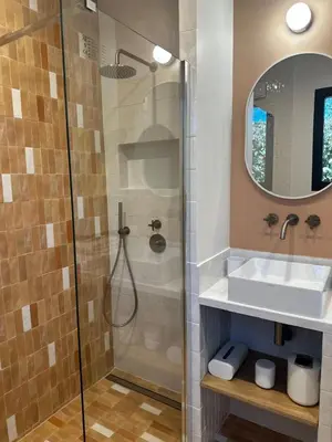 a bathroom with a shower and a sink and a mirror at La Réserve Hôtes in Aix-en-Provence