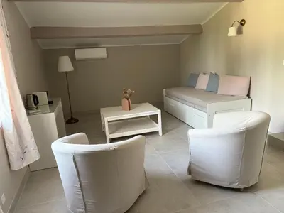 a bedroom with two chairs and a bed and a table at Au Bon Mistral in Monteux