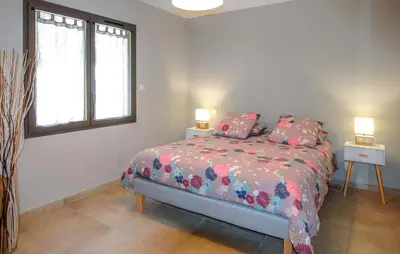 a bedroom with a bed with two night stands and two lamps at Charmant Mazet Provençal in Mazan