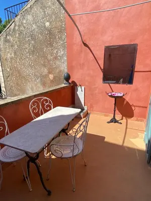 a table and two chairs and a television on a balcony at Syrius - Artist's apartment with terrace and view in Fontaine-de-Vaucluse