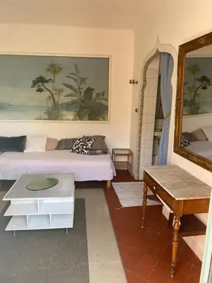 a room with two beds and a mirror and a table at Syrius - Artist's apartment with terrace and view in Fontaine-de-Vaucluse