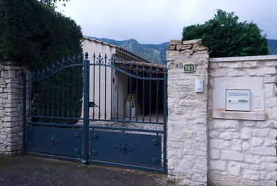a gate to a house with a stone wall at Catherine&Martial in Maubec