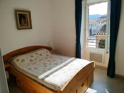 a bedroom with a wooden bed and a window at GitesLuberon 5 in Charleval