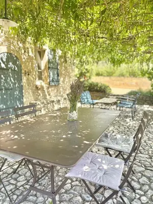 a table with two chairs and a vase on it at Bastidon Silvestre in Saint-Saturnin-les-Apt