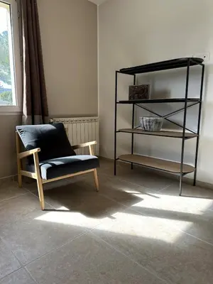 a living room with a chair and a shelf at 4 bedroom villa, private pool and garden in Cabrières-dʼAvignon
