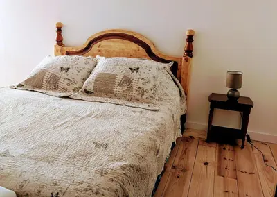 a bedroom with a bed and a table with a lamp at La poumo d'amour in La Tour-dʼAigues