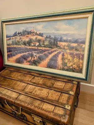 a painting sitting on top of a wooden chest at La poumo d'amour in La Tour-dʼAigues