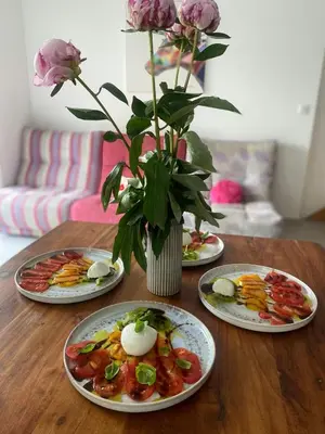 three plates of food on a wooden table with flowers at Peaceful Family Retreat In Aix-En-Provence in Puyricard