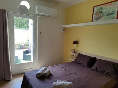 a bedroom with a bed and a sliding glass door at Chambre indépendante avec SDB privative in Avignon