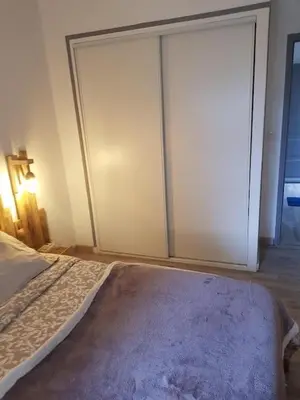 a bedroom with a bed and a sliding glass door at Les Marronniers Charmant petit appartement a La Tour d'Aigues Vaucluse in La Tour-dʼAigues
