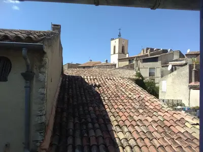 a tile roof of a building with a clock tower at La Bastide des Jourdans logement entier Duplex in La Bastide-des-Jourdans
