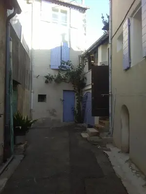 an alley with a blue door and a building at La Bastide des Jourdans logement entier Duplex in La Bastide-des-Jourdans