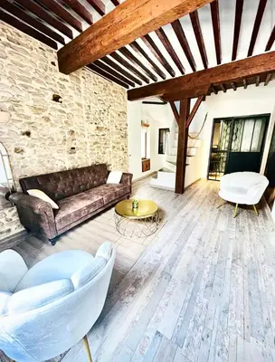 a living room with a couch and a table at L'Or du Temps - Jacuzzi privé in Lançon-Provence