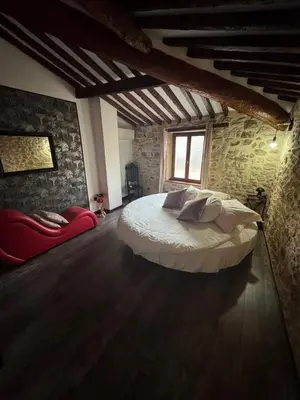a bedroom with a bed and a brick wall at L'Or du Temps - Jacuzzi privé in Lançon-Provence