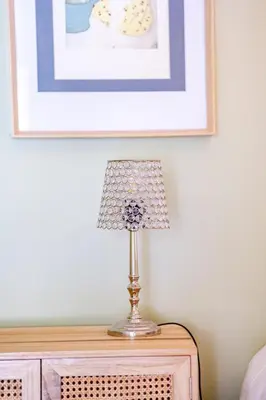 a lamp on a dresser in a bedroom with a picture at Souviens-toit in Puget