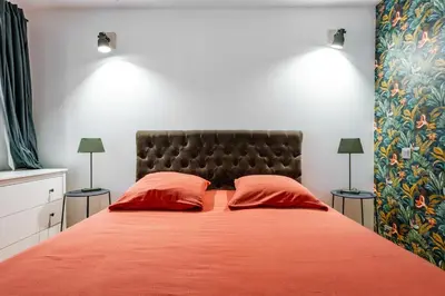 a bedroom with a large bed with two red pillows at Souviens-toit in Puget