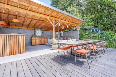 a patio with a table and chairs on a deck at Souviens-toit in Puget