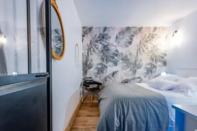 a small bedroom with a bed and a wall mural at Souviens-toit in Puget