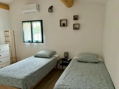 a bedroom with two twin beds and a window at Maison rénovée 3 chambres in Mollégès